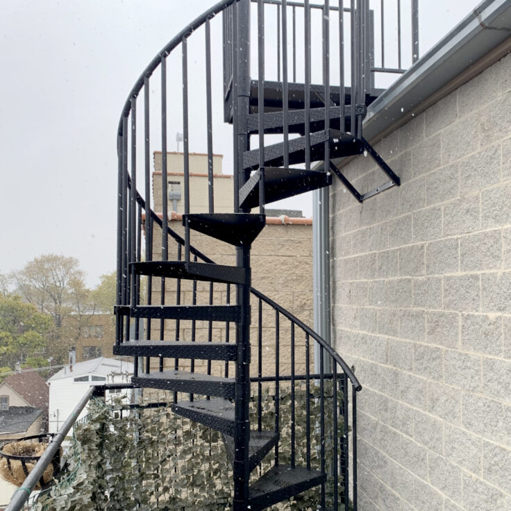 Traditional wrought iron spiral stairwell powder coated black in Chicago